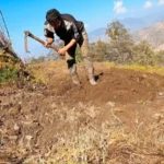 Nepali farmer using Khudalo in mountain field