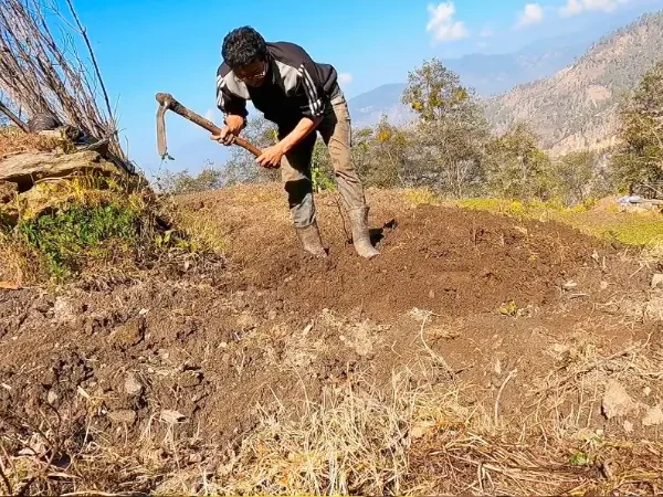 Nepali farmer using Khudalo in mountain field